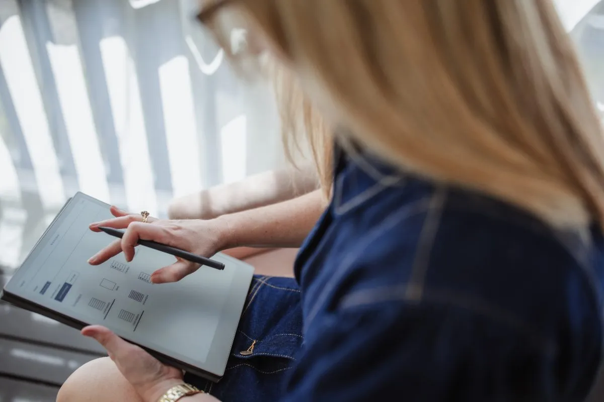 Close-up of Kristy sketching a marketing plan on a tablet with a stylus