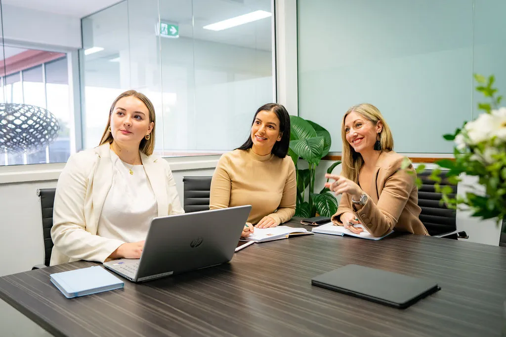 Kristy leading a marketing strategy meeting with two team members in a boardroom