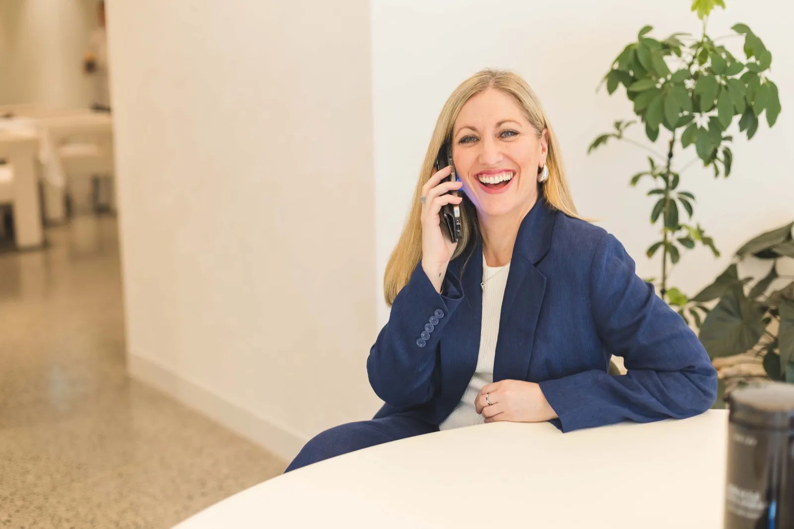 Kristy from Hunter Marketing Co. smiling while taking a phone call at a desk